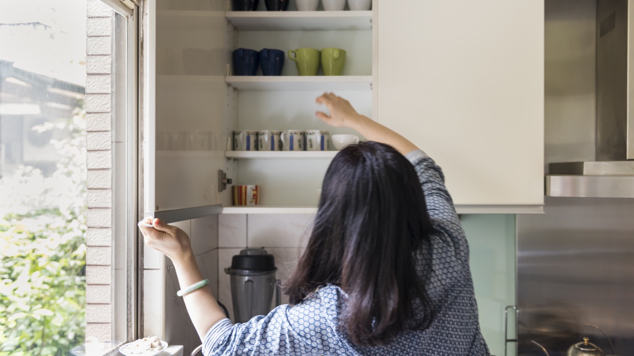 mulher organizando armário da cozinha