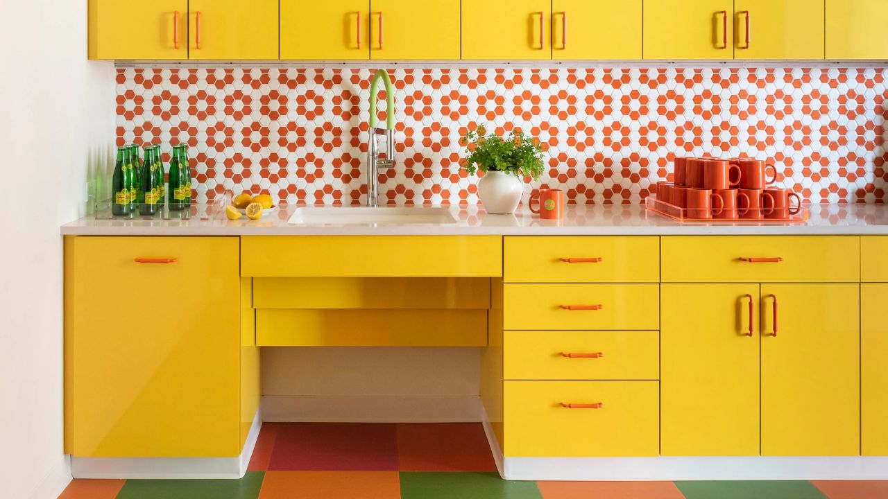 cozinha amarela com blacksplash florido em laranja